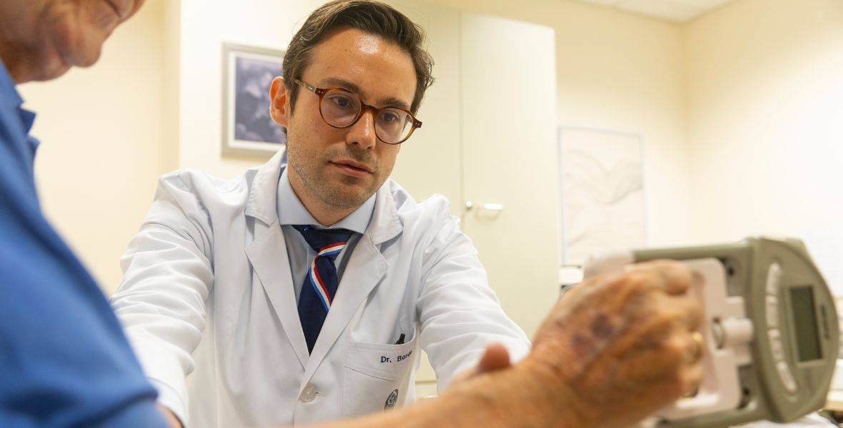 Foto del Dr. Miguel German Borda, geriatra y neurólogo de la Clínica Universidad de Navarra, realizando la prueba de sarcopenia a uno de sus pacientes en la consulta
