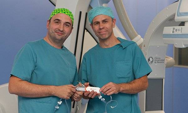cirujanos-vasculares-clinica-universidad-navarra Los doctores Ignacio Leal y Lukasz Grochowicz muestran el introductor que facilita la reversión del flujo sanguíneo en esta nueva técnica.