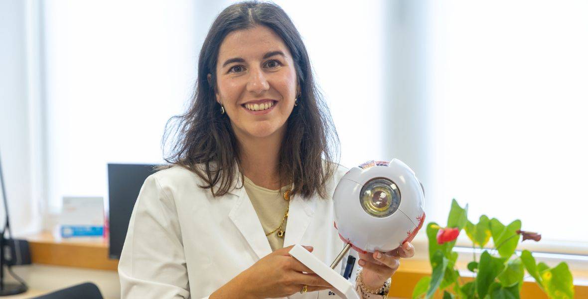 Foto de la Dra. Miriam de la Puente, oftalmóloga de la Clínica Universidad de Navarra, con un modelo anatómico del ojo