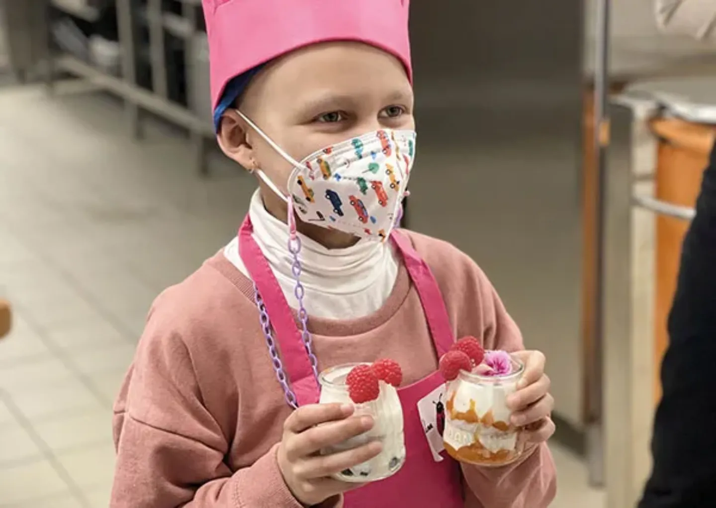 Niña con un postre en el taller de cocina saludable. CUN Imagen de una niña con uno de los postres realizados en el taller de cocina para niños sobre alimentación saludable en el cáncer. Clínica Universidad de Navarra.