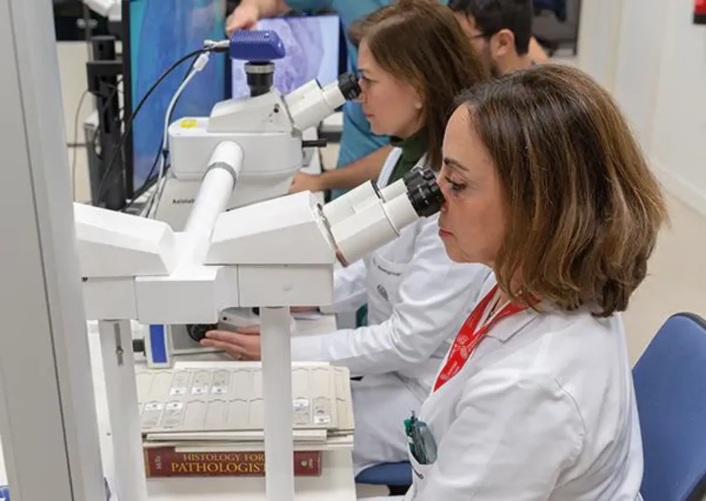 Profesionales. Anatomía Patológica. Clínica Universidad de Navarra Imagen de profesionales de anatomía patológica mirando por el microscopio. Clínica Universidad de Navarra