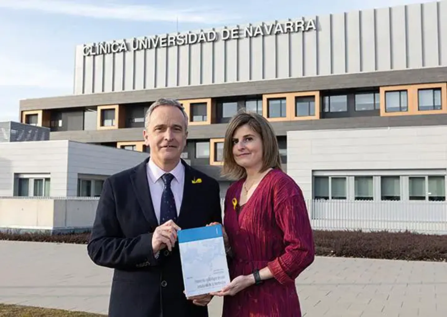 El Dr. Martí y la Dra. Moran, autores del libro "Protección radiológica en una instalación de protonterapia" Foto del Dr. Martí y la Dra. Moran, radiofísicos, junto a un ejemplar del libro "Protección radiológica en una instalación de protonterapia" en la fachada de la sede de Madrid.