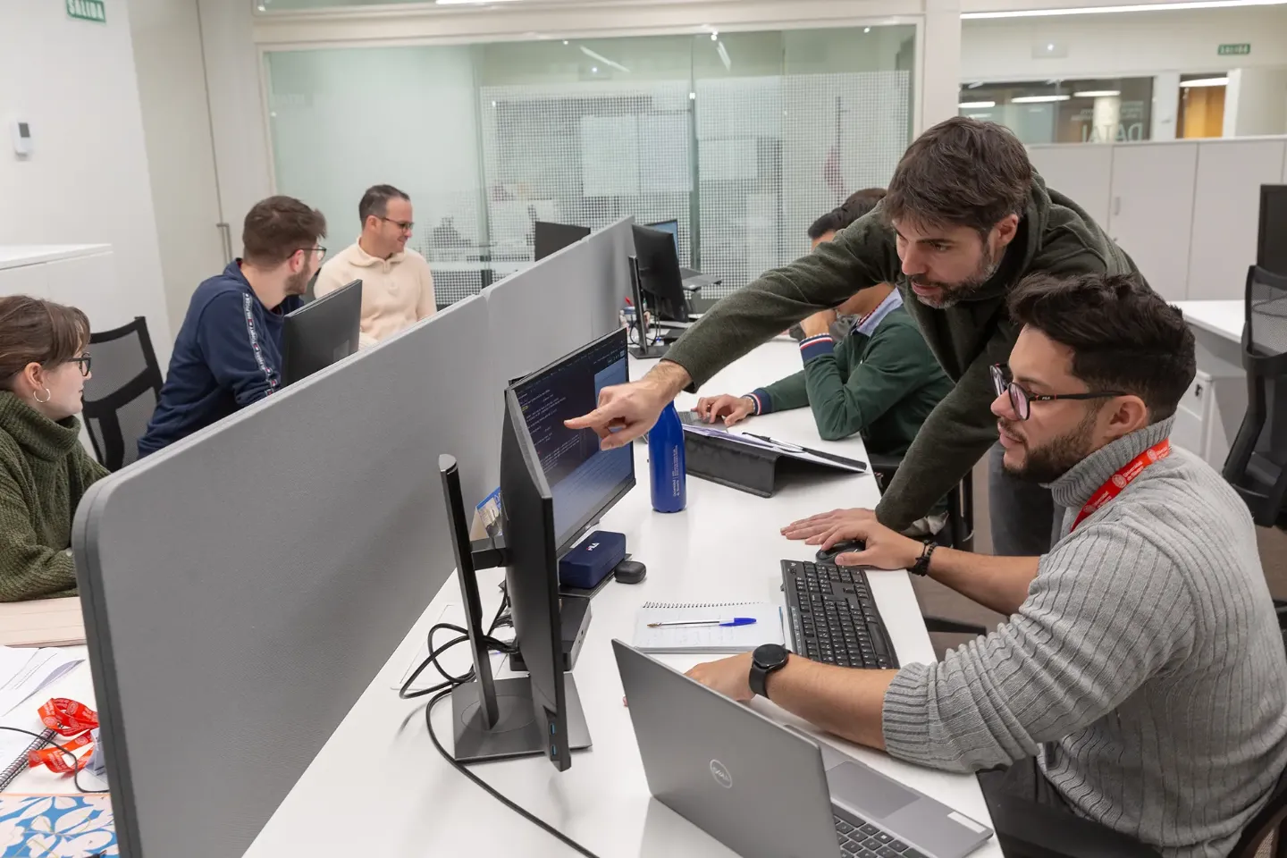 Imagen de varias personas de DATAI trabajando en sus ordenadores en una sala. 