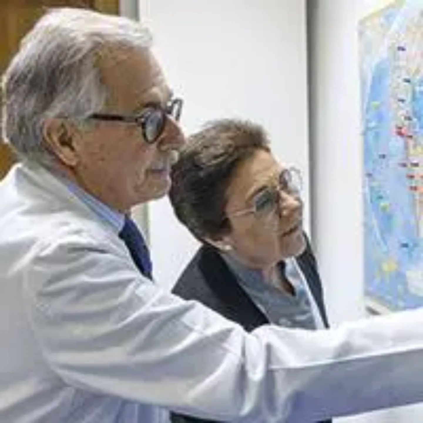 Imagen del Dr. José Antonio Páramo y la enfermera Mari Francis mirando un mapamundi