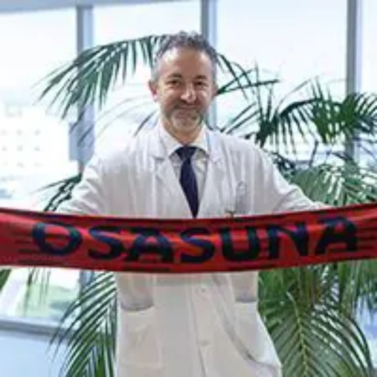 Imagen del Dr. Andrés Valentí sujetando una bufanda de Osasuna. Clínica Universidad de Navarra