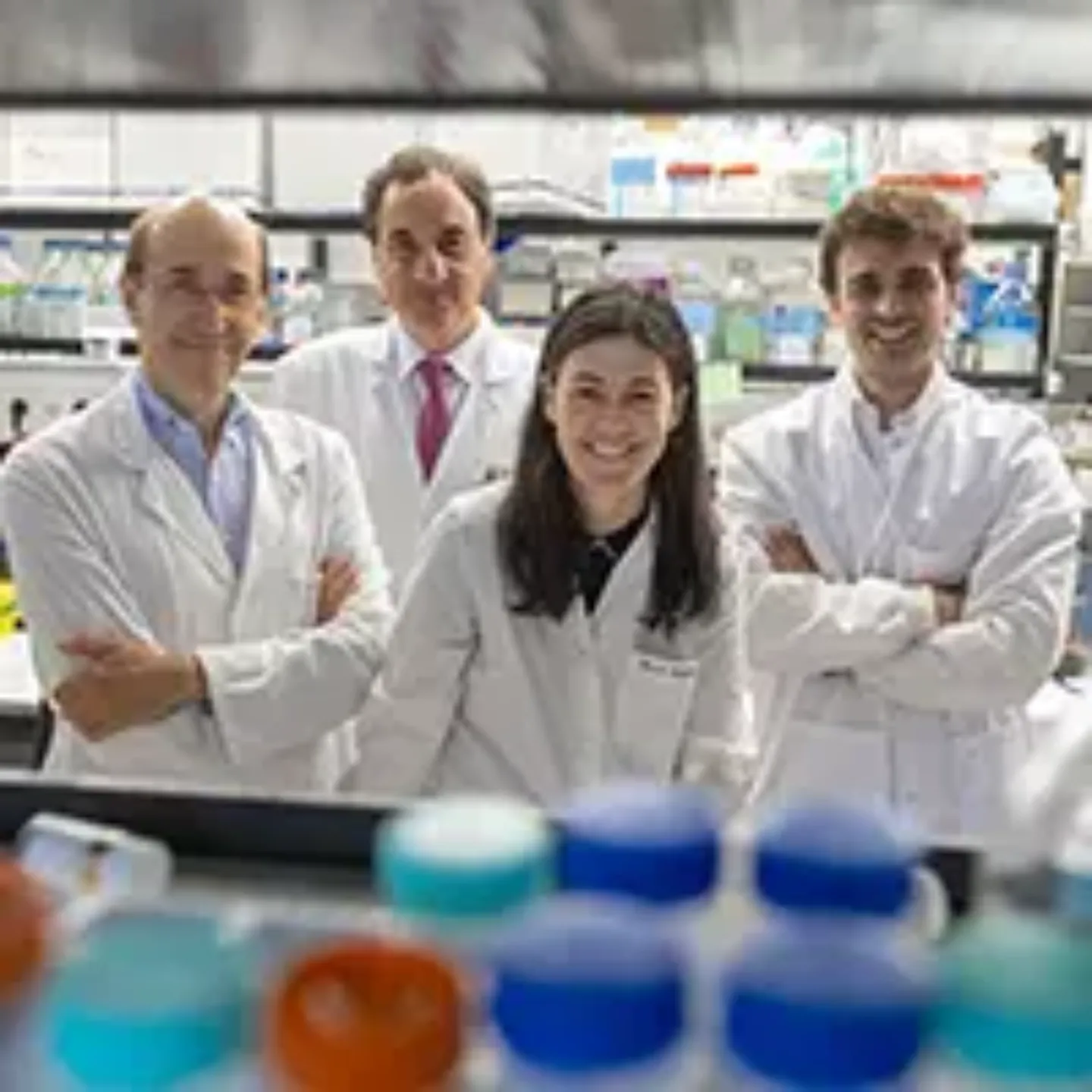 Imagen de cuatro investigadores con bata blanca posando en un laboratorio.