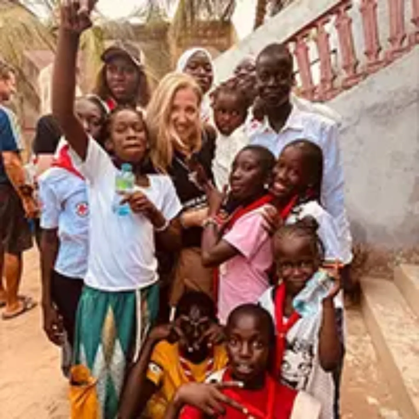 Una trabajadora de la Clínica Universidad de Navarra en África rodeada de población local en verano durante su voluntariado. 