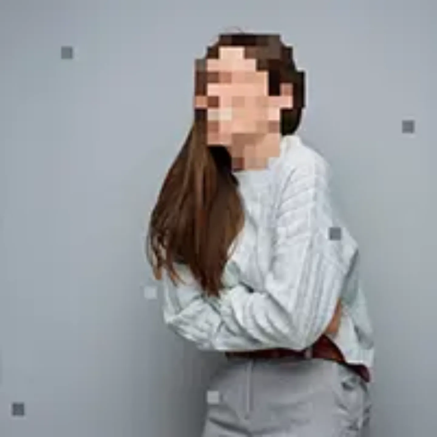 Imagen de una mujer con la cara pixelada sujetándose la tripa como si le doliera el estómago. 