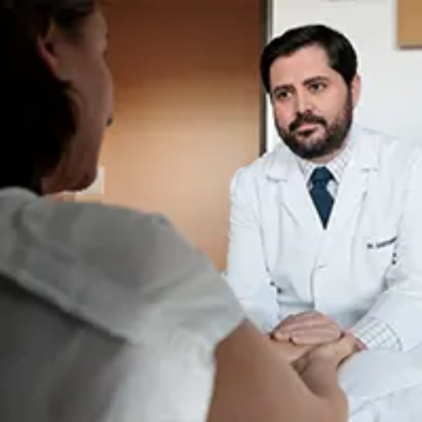 Imagen del Dr. Eduardo Castañón, de la Clínica Universidad de Navarra, dando la mano a una paciente. 
