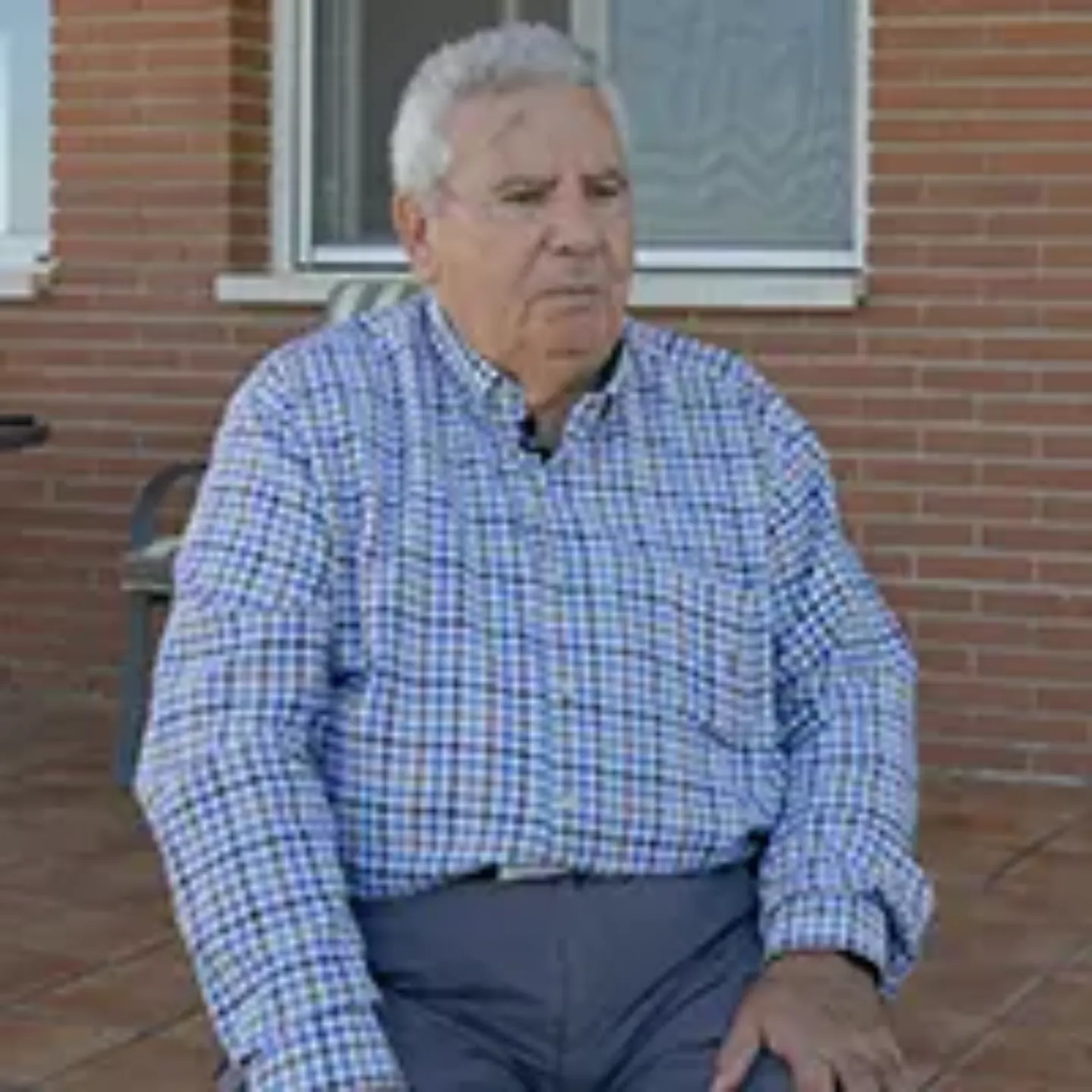 Imagen de Juan Cruz Elías, paciente de la Clínica Universidad de Navarra, sentado en una silla en la terraza de su casa. 