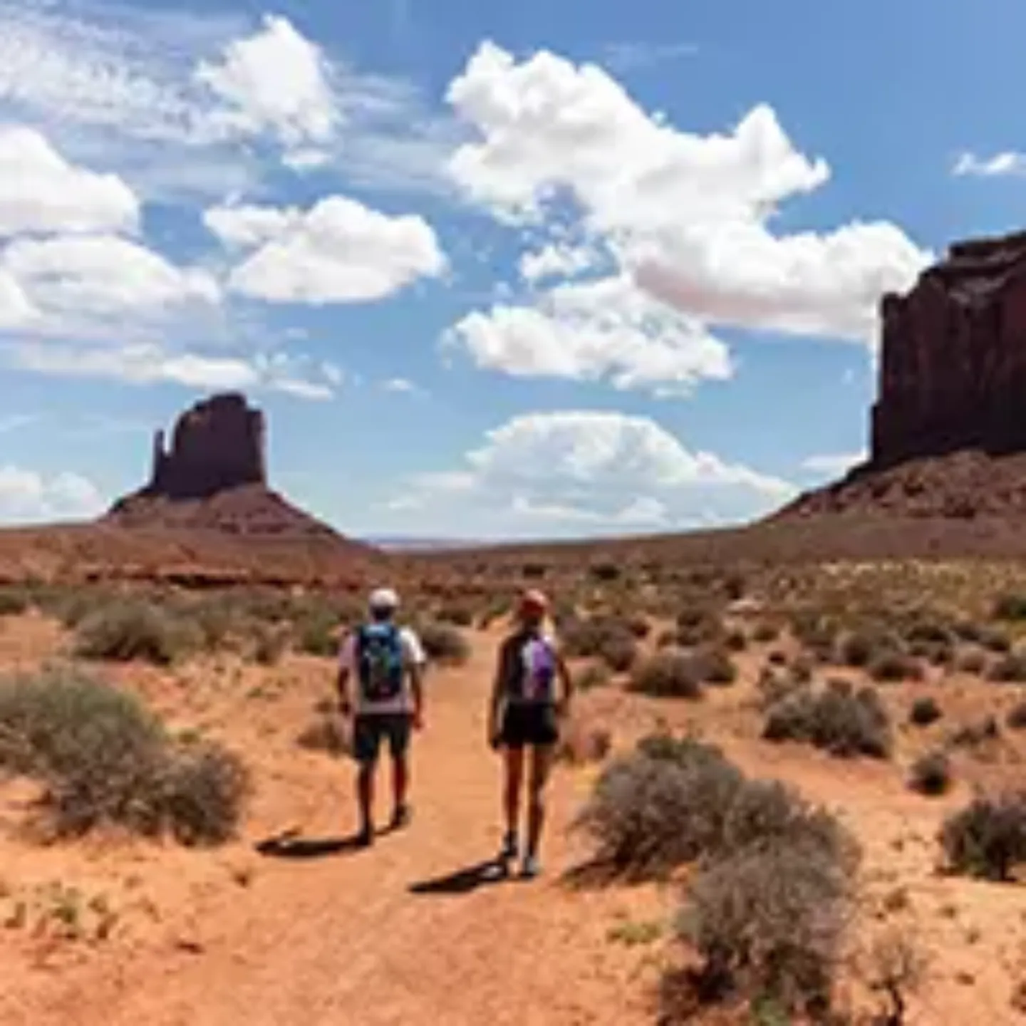 Imagen de dos personas caminando por un desierto.
