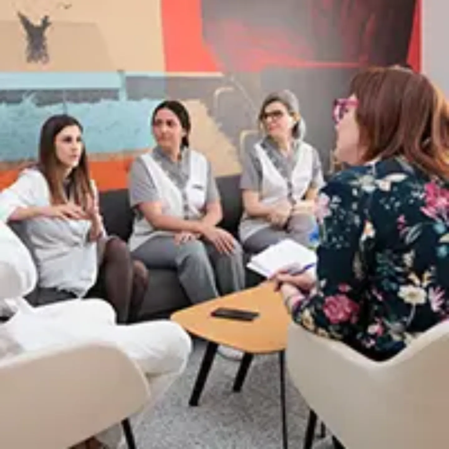 Imagen de dos enfermeras y una doctora especializadas en cardiooncología siendo entrevistadas por una periodista en una sala de la Clínica Universidad de Navarra.