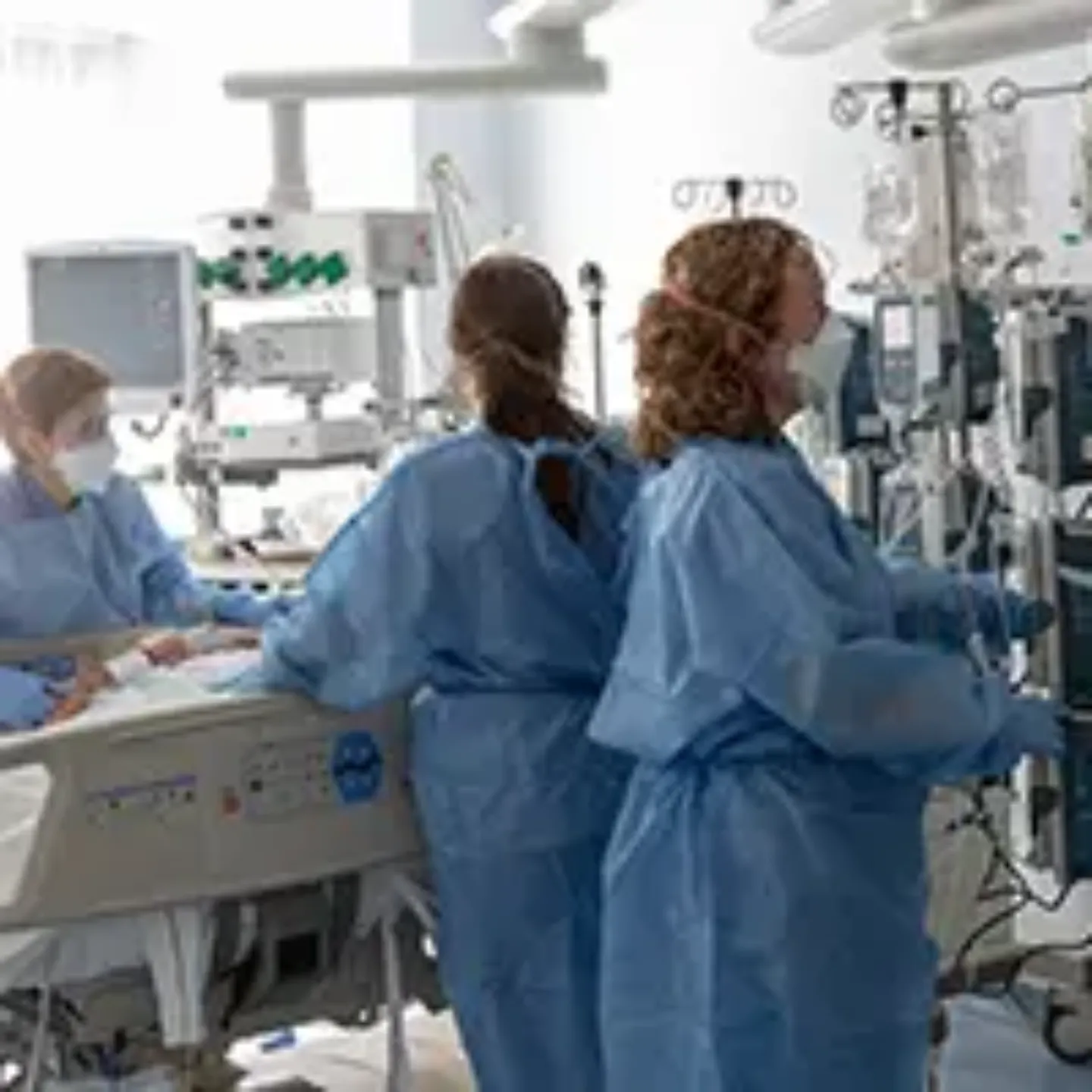 Imagen de tres enfermeras atendiendo a un paciente de la UCI de la Clínica Universidad de Navarra.