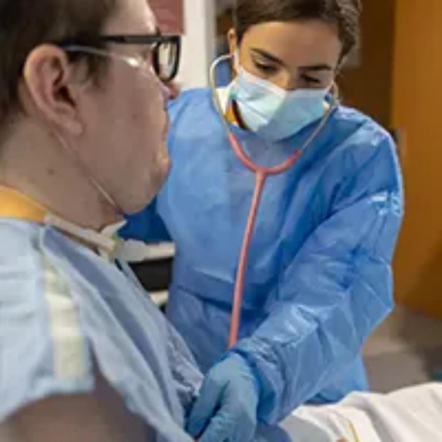 Imagen de una doctora auscultando a un paciente hospitalizado en la Unidad de Cuidados Intermedios de la Clínica Universidad de Navarra.