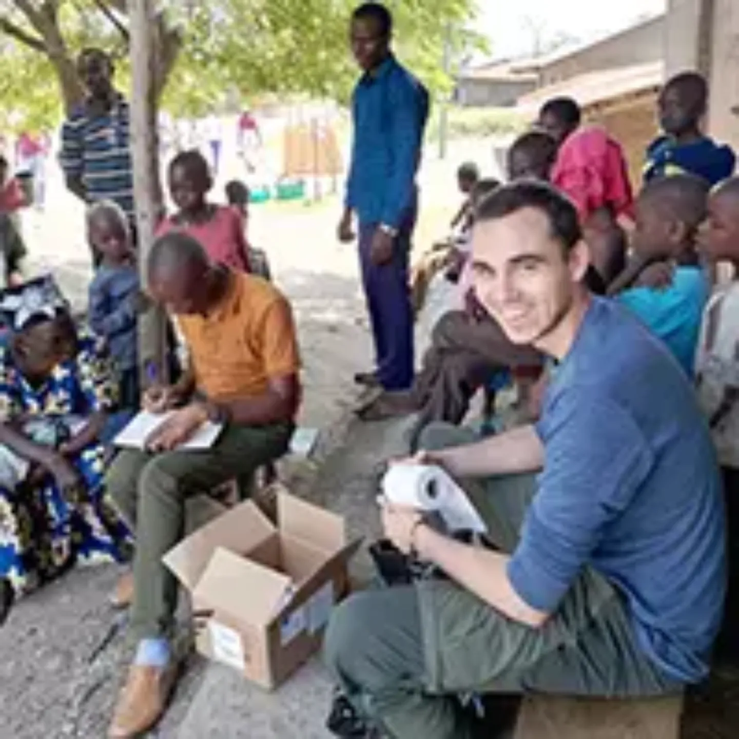 Imagen de Manuel Pina rodeado de gente local en un pueblo de Uganda.
