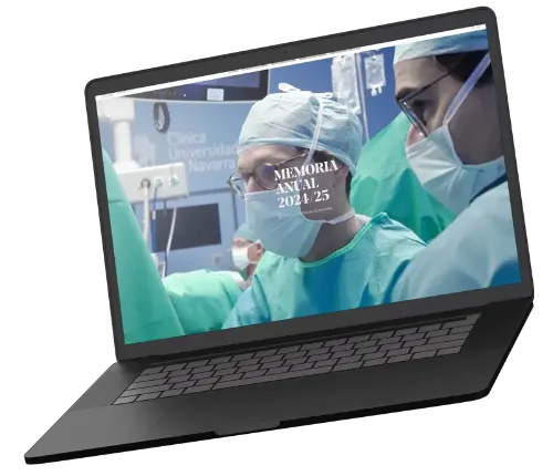 Imagen de un ordenador portátil abierto donde se ve en la pantalla la portada de la Memoria digital 2024-25. Clínica Universidad de Navarra