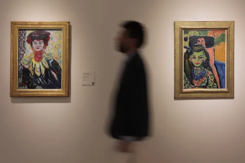 Imagen desenfocada y de perfil del Dr. Álvaro Cabello, cirujano plástico de la Clínica Universidad de Navarra, caminando por un sala del Museo Thyssen y dos cuadros de Kirchner en la pared.