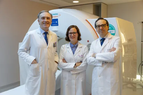 Imagen de tres médicos posando delante de una resonancia magnética en la Clínica Universidad de Navarra.