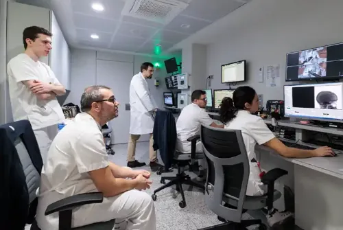 Imagen de los técnicos de radioterapia observando las pantallas en la sala de control de la Unidad de Protonterapia de la Clínica Universidad de Navarra.