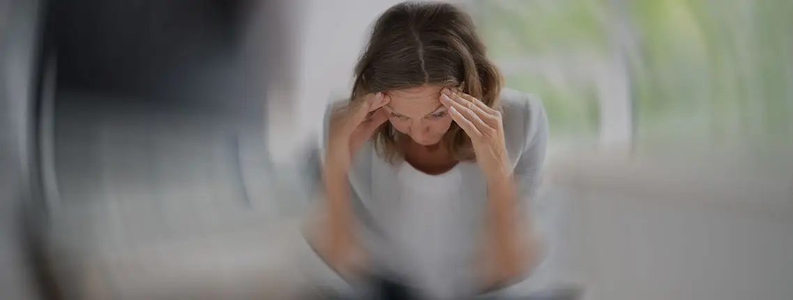 Imagen de una mujer con síntomas de una crisis de vértigo, todo le da vueltas.