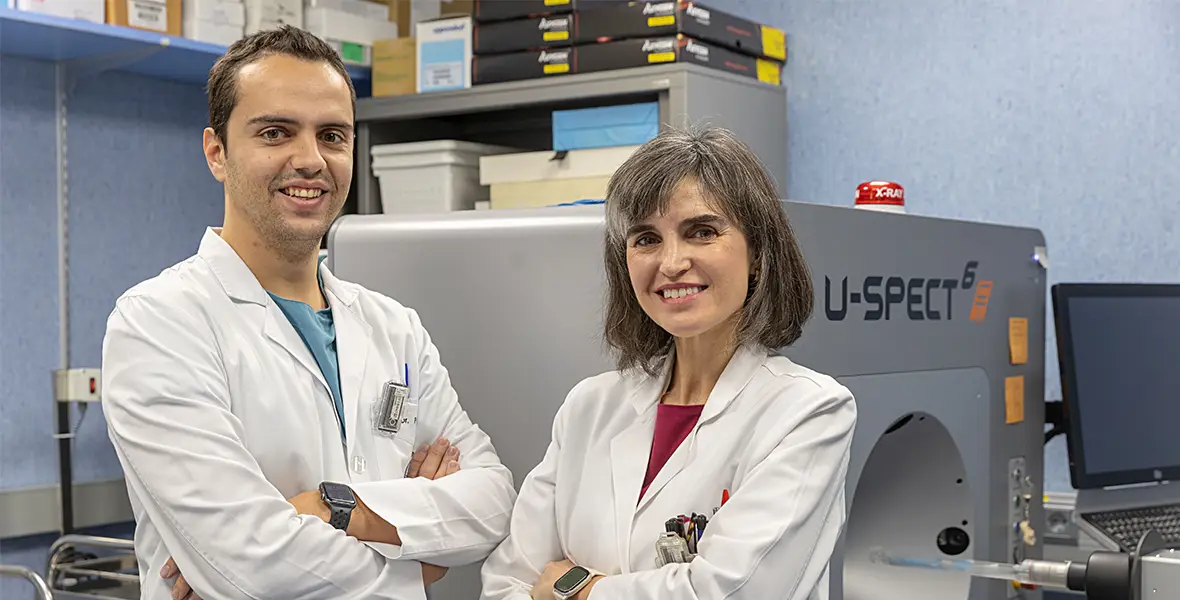 Foto del Dr. Félix Pareja del Río junto a la Dra. María Collantes en el laboratorio de radiodiagnóstico junto a un PET "en miniatura"