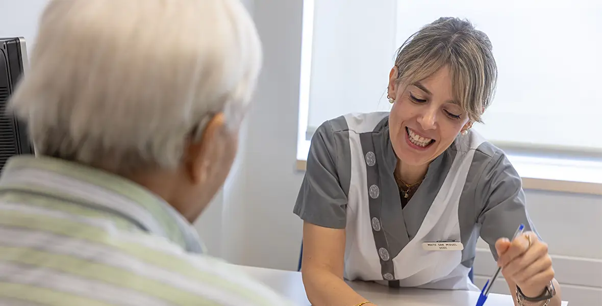 Foto de una enfermera con un paciente en la Unidad Central de Ensayos Clínicos en la que se le ve explicándole cuestiones sobre la medicación. 