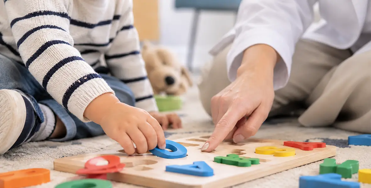 Foto de una profesional haciendo un ejercicio infantil para ilustrar una noticia sobre la vuelta al cole y pediatria